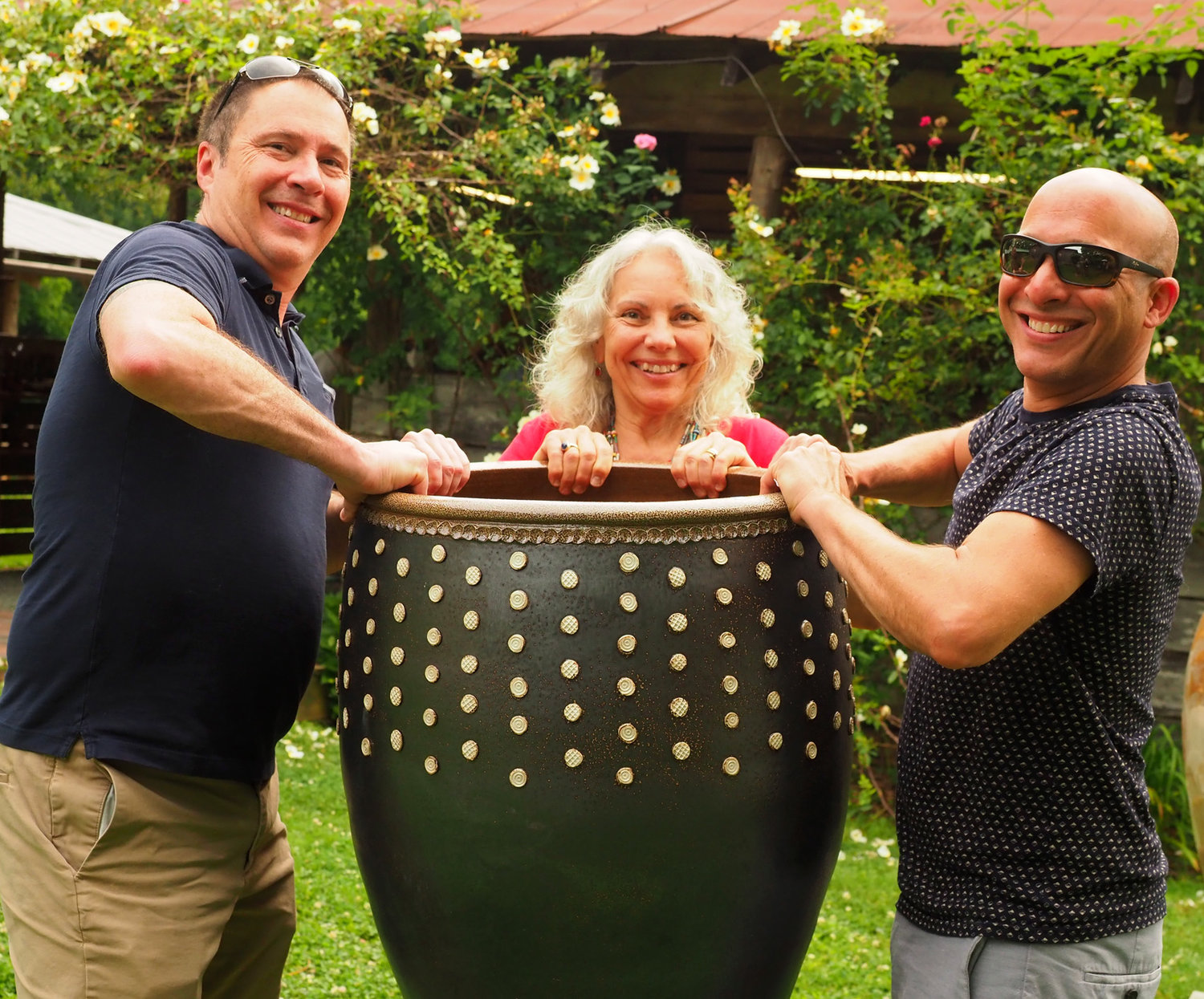 Brian Stratton and Jason Sandguist of Raleigh with Carol Hewitt, posing in pottery near the kiln's opening.